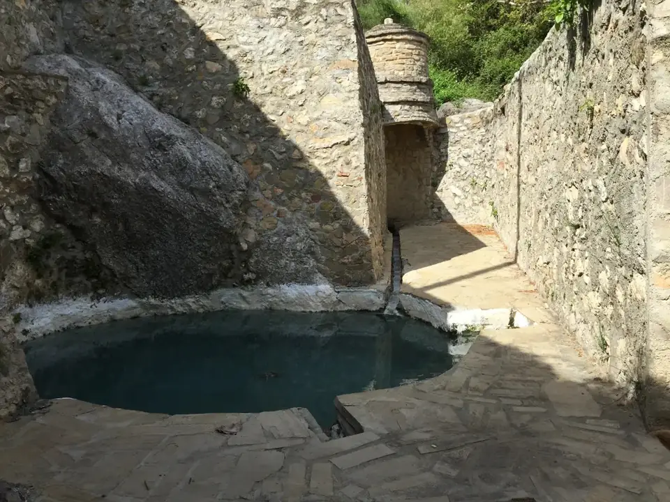Poza de aguas sulfurosas de los Baños de Vilo entre muros de piedra