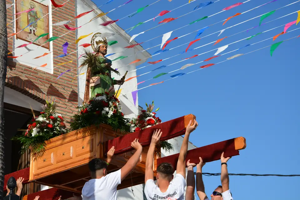 Procesión de San Fernando Rey por las calles de Mondrón, con banderines de colores