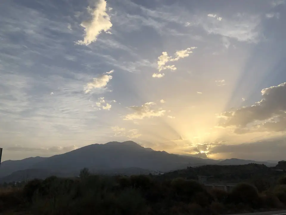 Rayos de sol detrás de la sierra al atardecer desde Mondrón