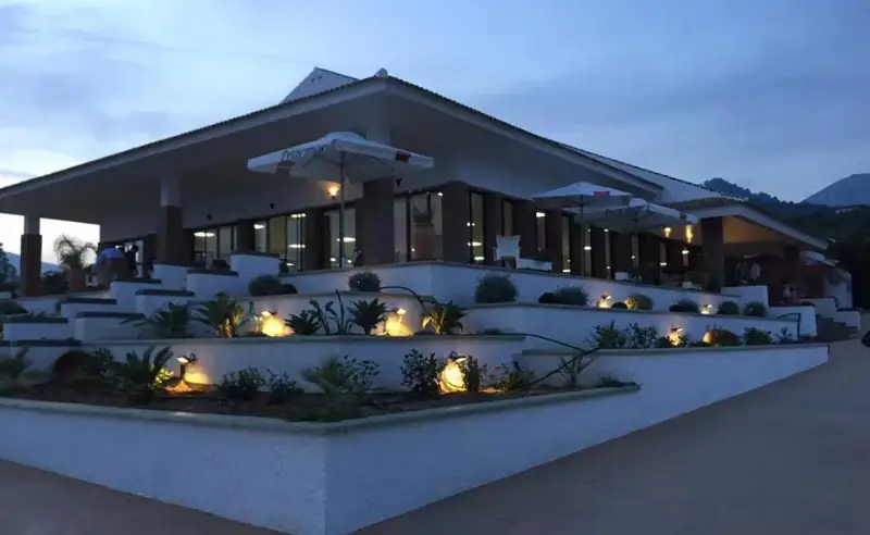 Edificio de Finca Oasis Las Palmeras iluminado al anochecer